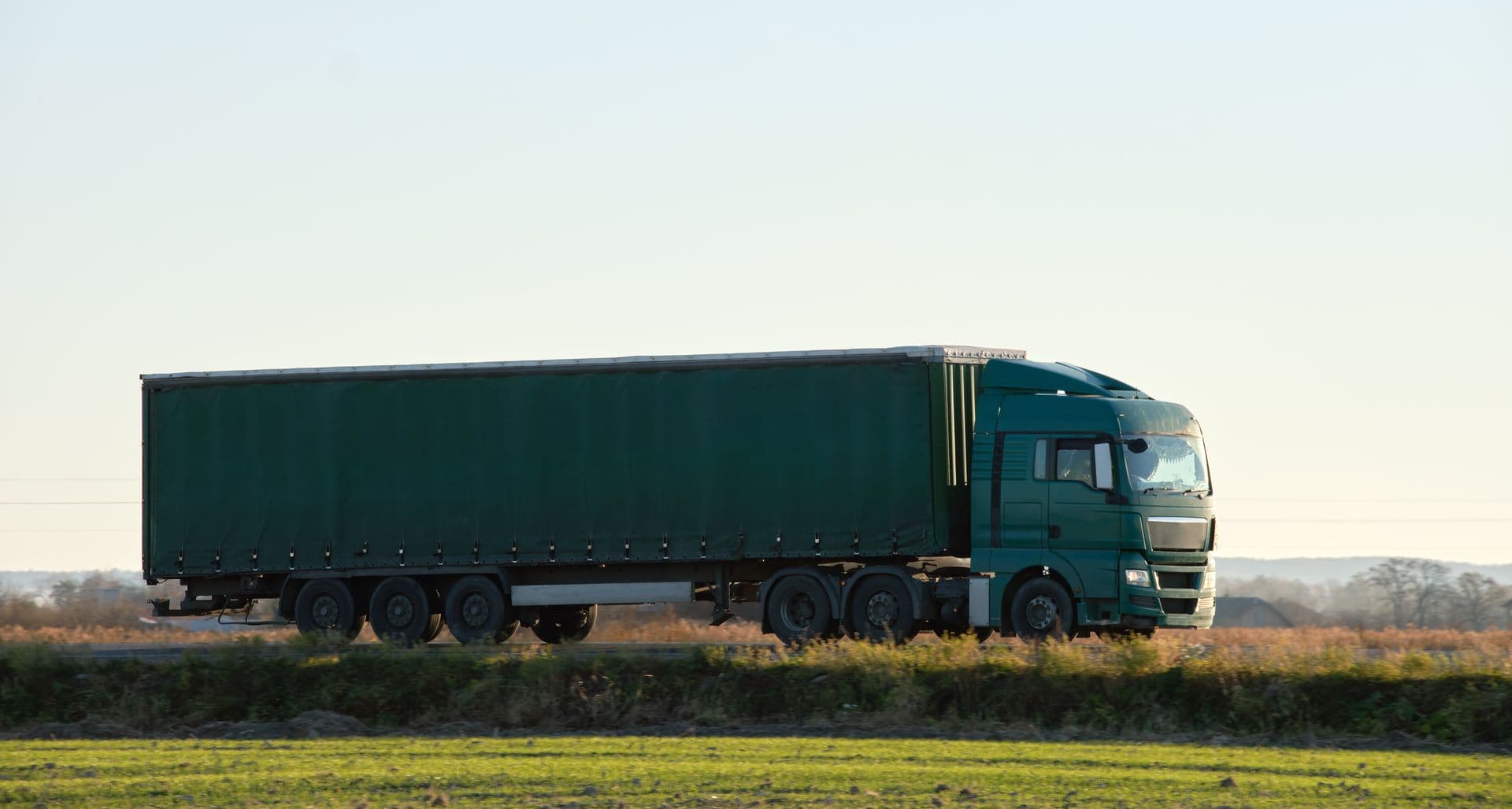 Tráiler de carga circulando por una carretera abierta.