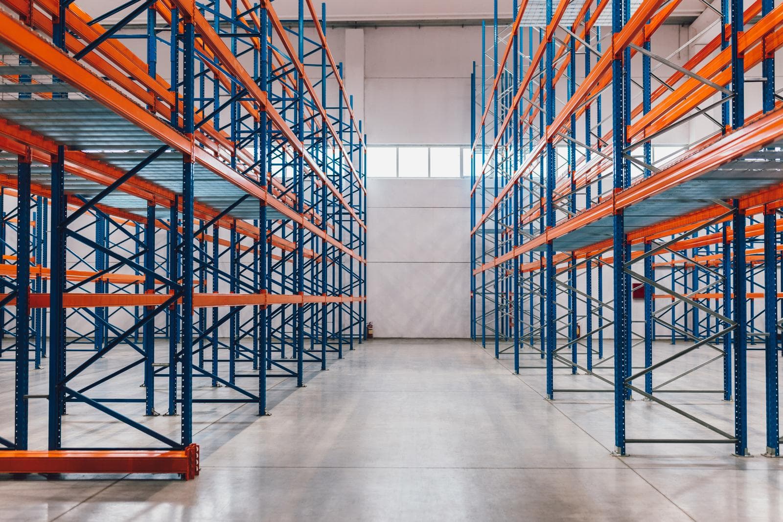Interior de un almacén logístico, con pasillos de racks ordenados